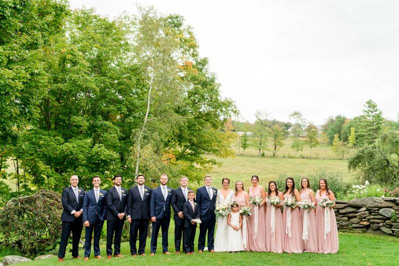 Bridesmaids in blush and groomsmen in navy with bride and groom on wedding day at the Inn at the Rou