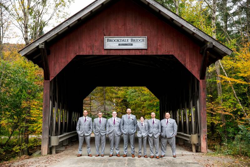 Groomsmen photo under covered bridge in Vermont during fall wedding