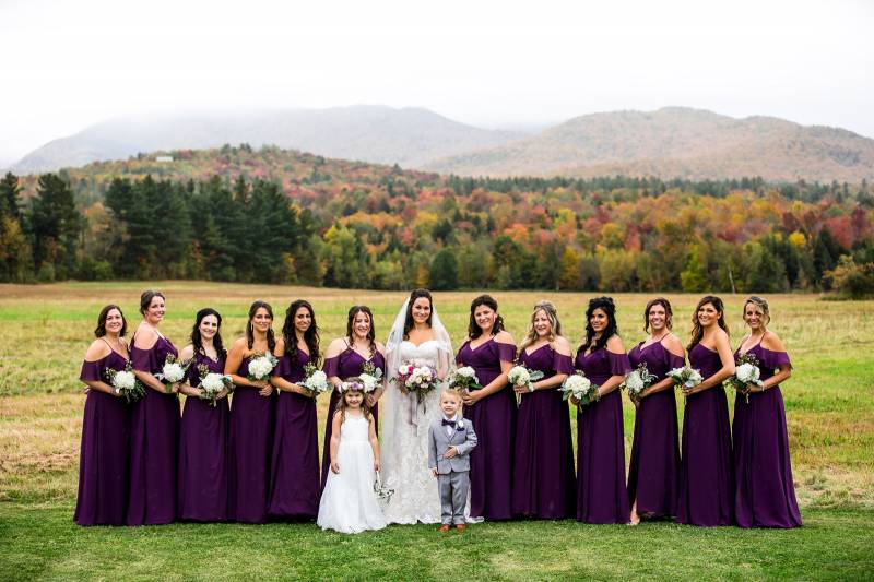 Bridesmaids in plum dresses with fall foliage during autumn wedding