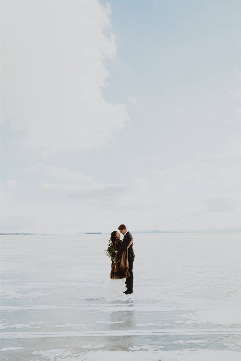 Couple standing on frozen Lake Champlain during winter elopement