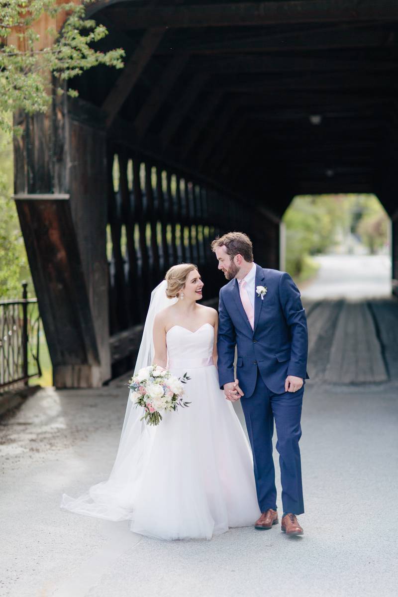 Bride and groom under covered bridge during spring wedding at the Woodstock Inn in Vermont