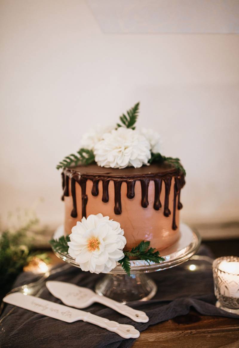 One tier wedding cake featuring chocolate drizzle and real flowers