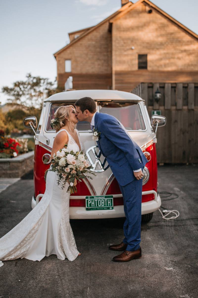 Bride and groom kissing in front of VW bus photo booth from the Photobotoh Planet