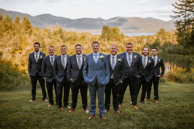 Grey groomsmen suits featured in wedding party portrait at the Mountain Top Inn and Resort