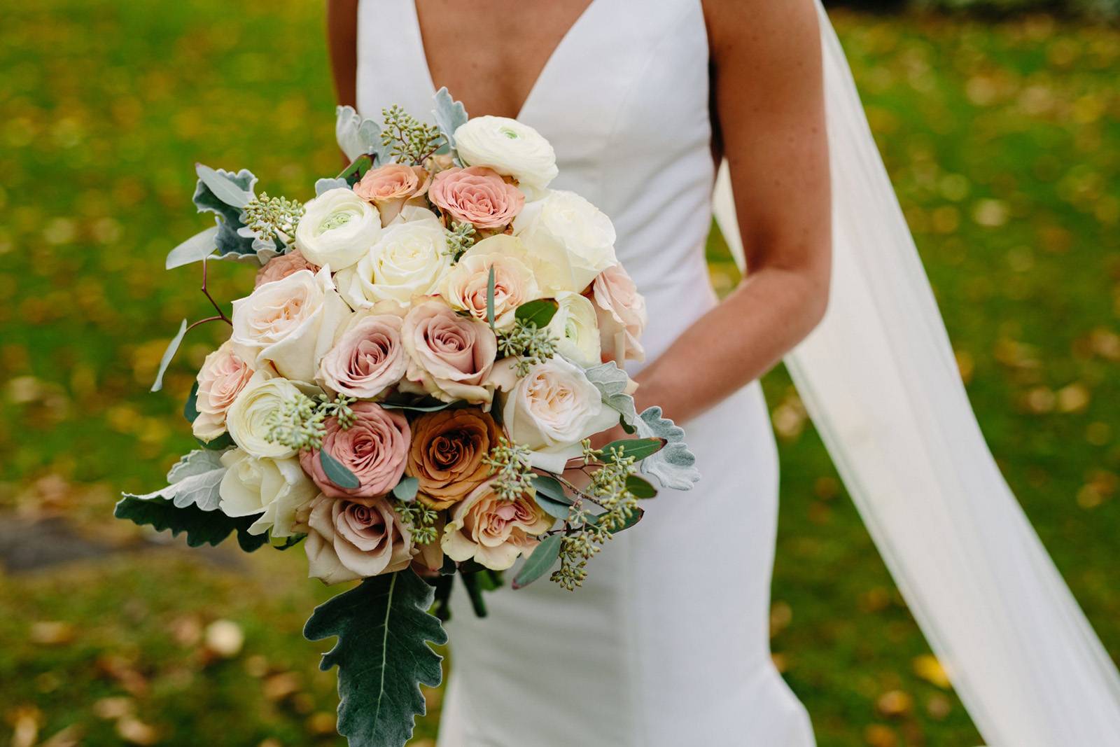 Close up of fall bridal bouquet with blush, white and terra cotta roses