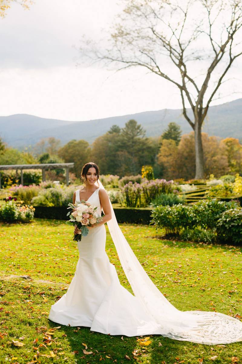 Black tie elegant bridal attire with long veil and terra cotta and pastel flowers for fall wedding