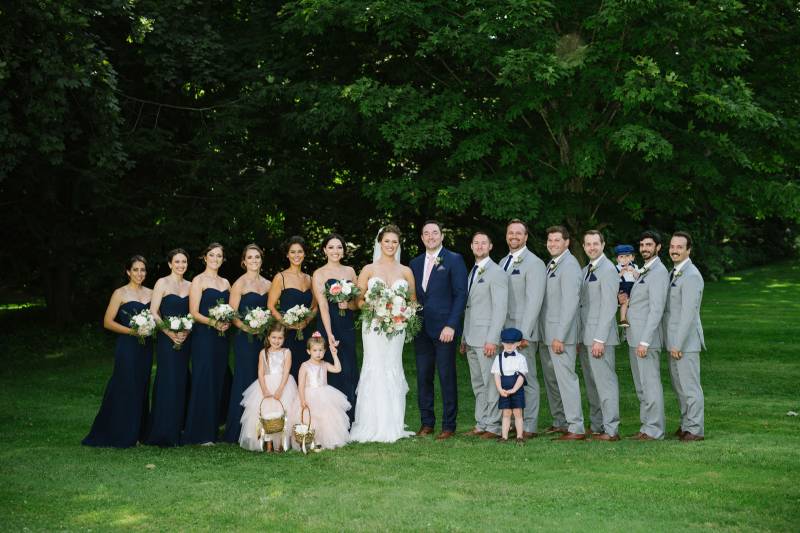Elegant wedding party featuring navy blue long bridesmaid dresses and grey groomsmen suits