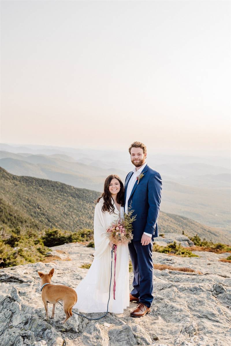 Couple standing on mountain top for Vermont elopement with their dog