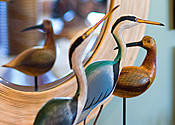 wood carvings of birds with reflection in mirror