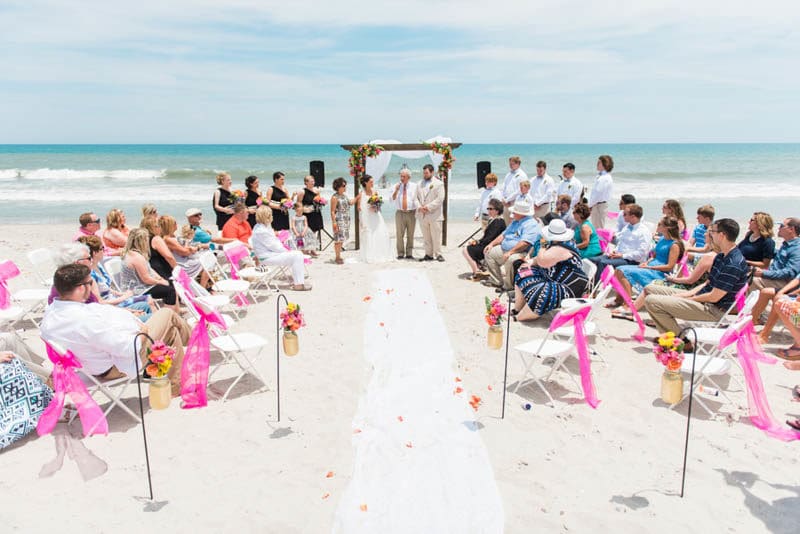 Beach Wedding At The Pelican Clubhouse Paring Vendors Venue Pelican Beach Clubhouse Photographer Lisa Marshall Photography Florist Flowers By Noel Flores Cake A Bite Of Love Cakes