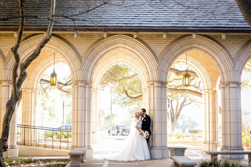 Bride and groom kissing under arches