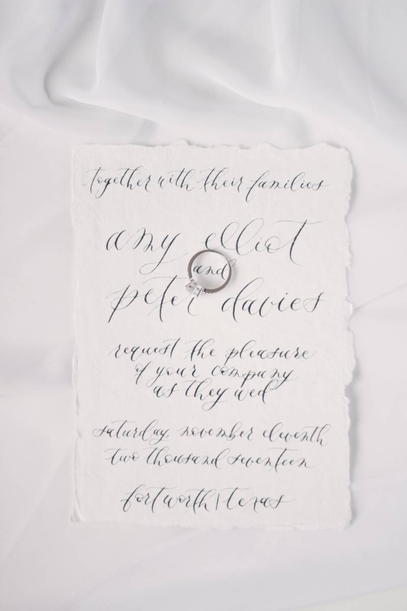 White wedding invitation with black calligraphy