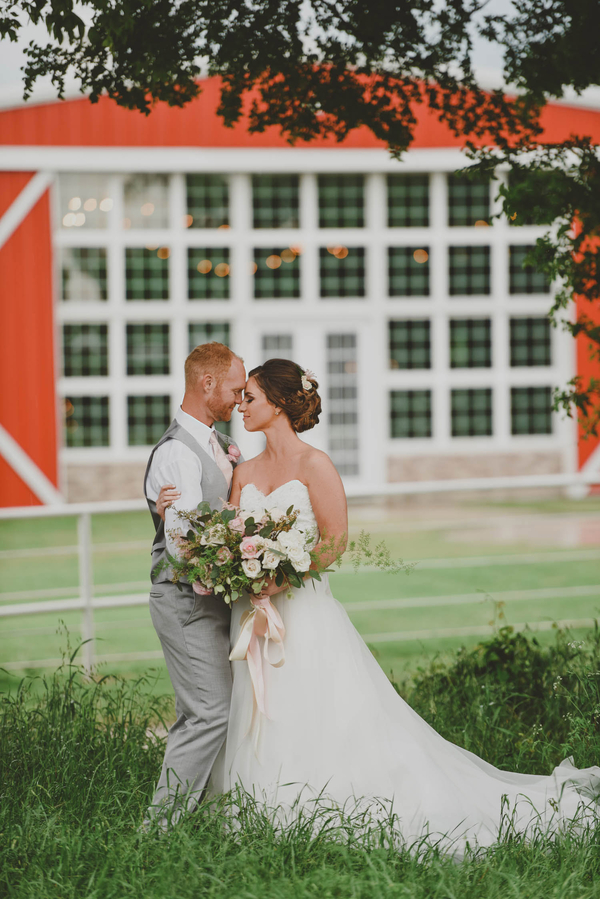 Bride and groom in front of red barn