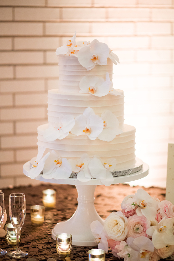 White buttercream wedding cake with orchids