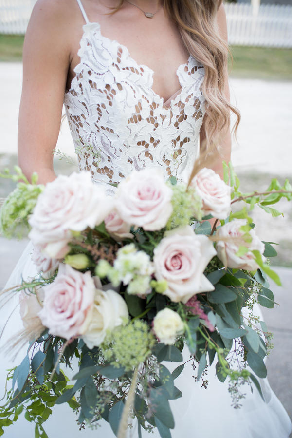 Gorgeous pink floral bouquet and lace wedding dress