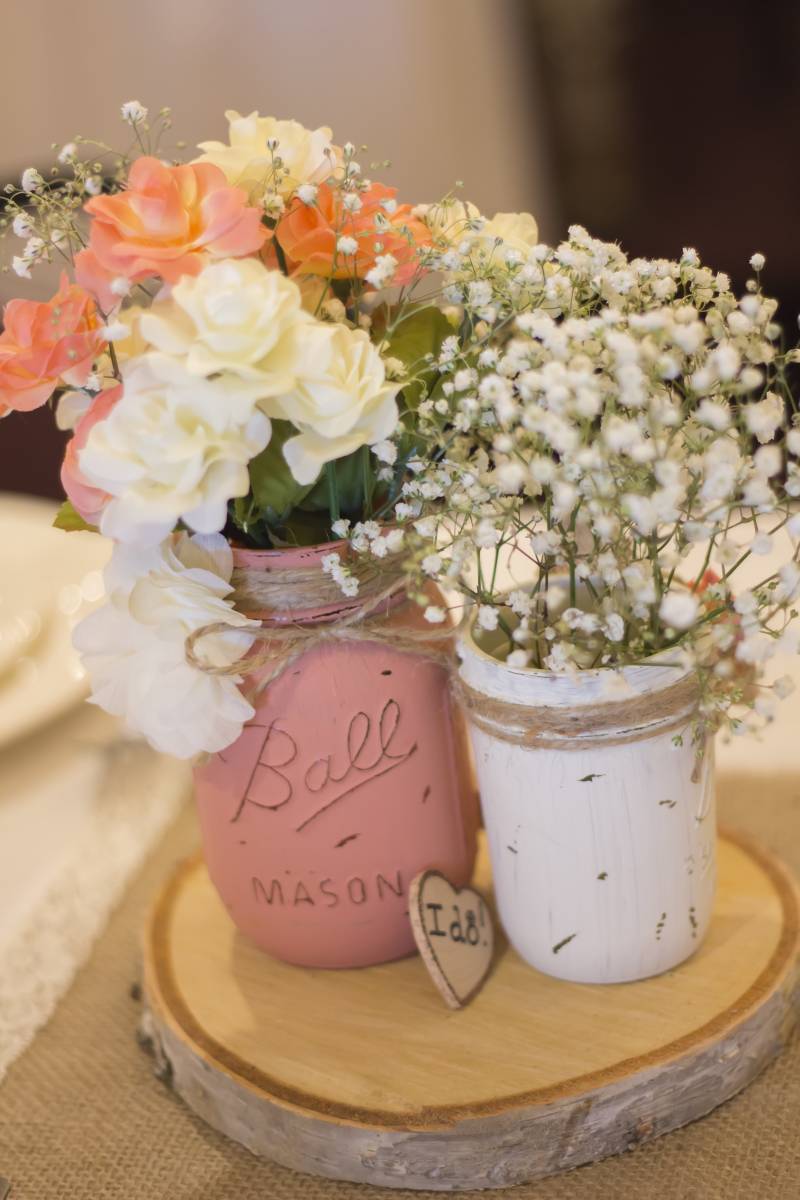 Wildflower nature wedding centerpieces with wood slices, bottles