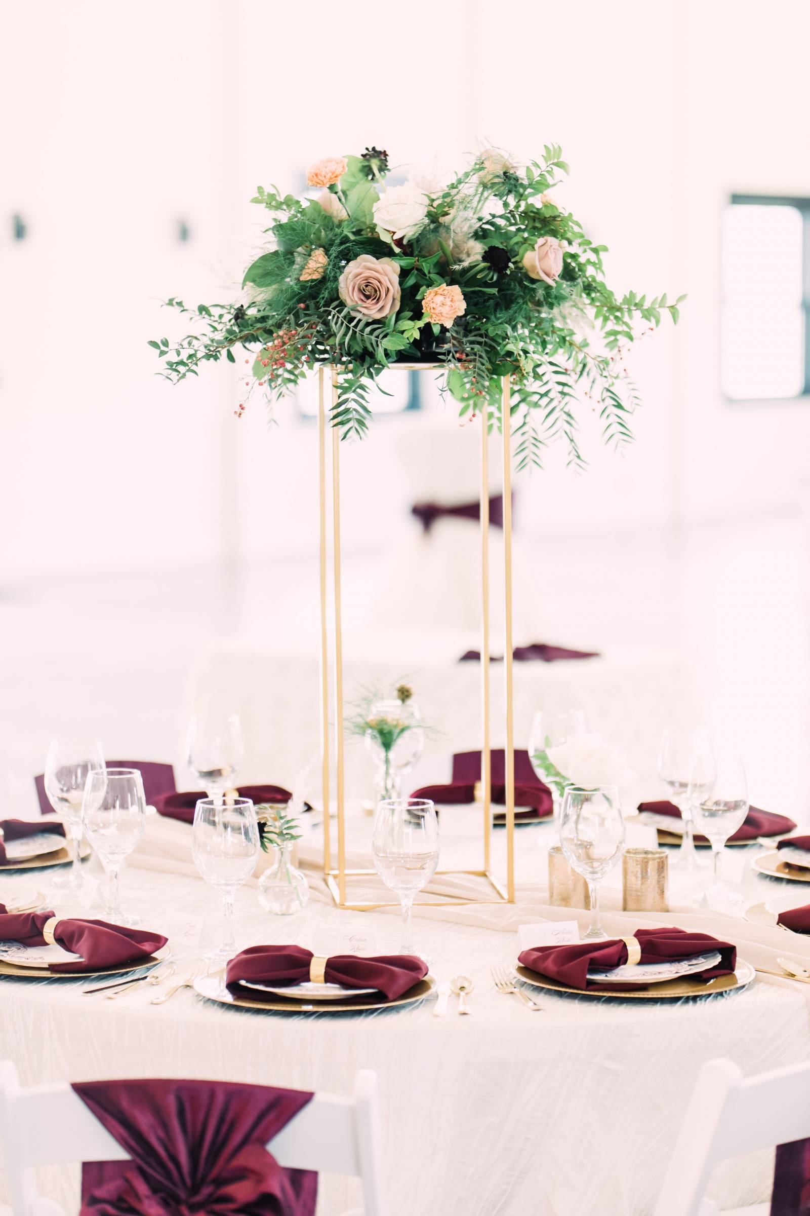 tall centerpieces in burgundy place setting