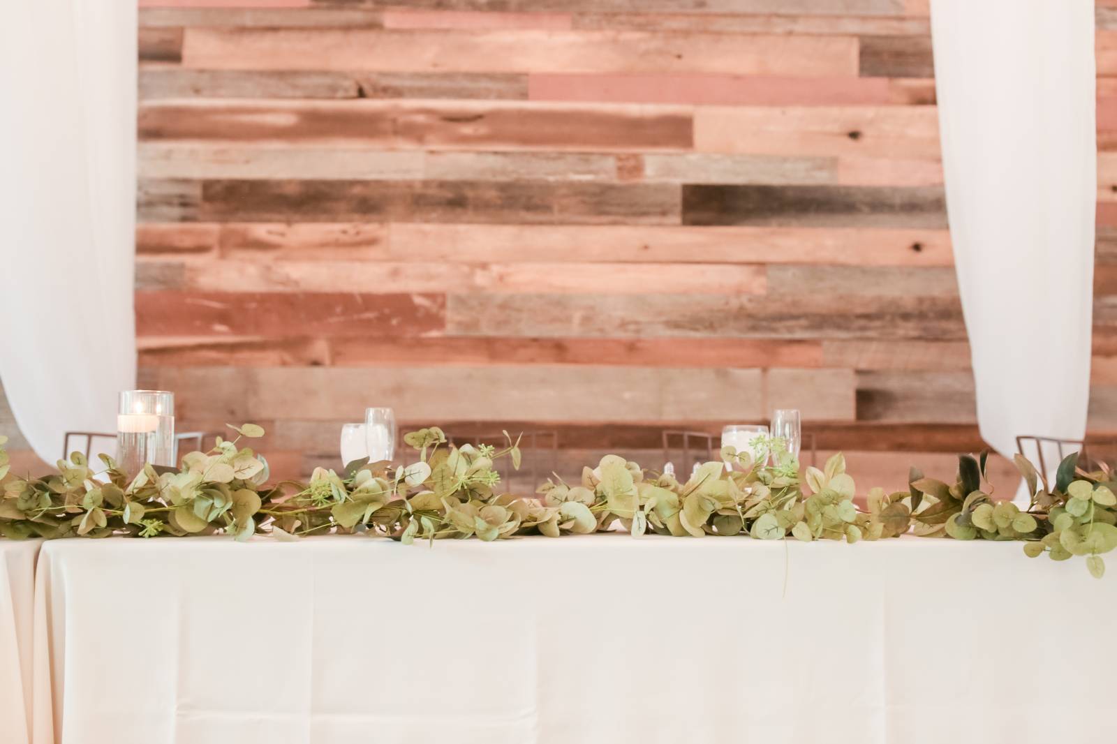 greenery runners with candles on head table