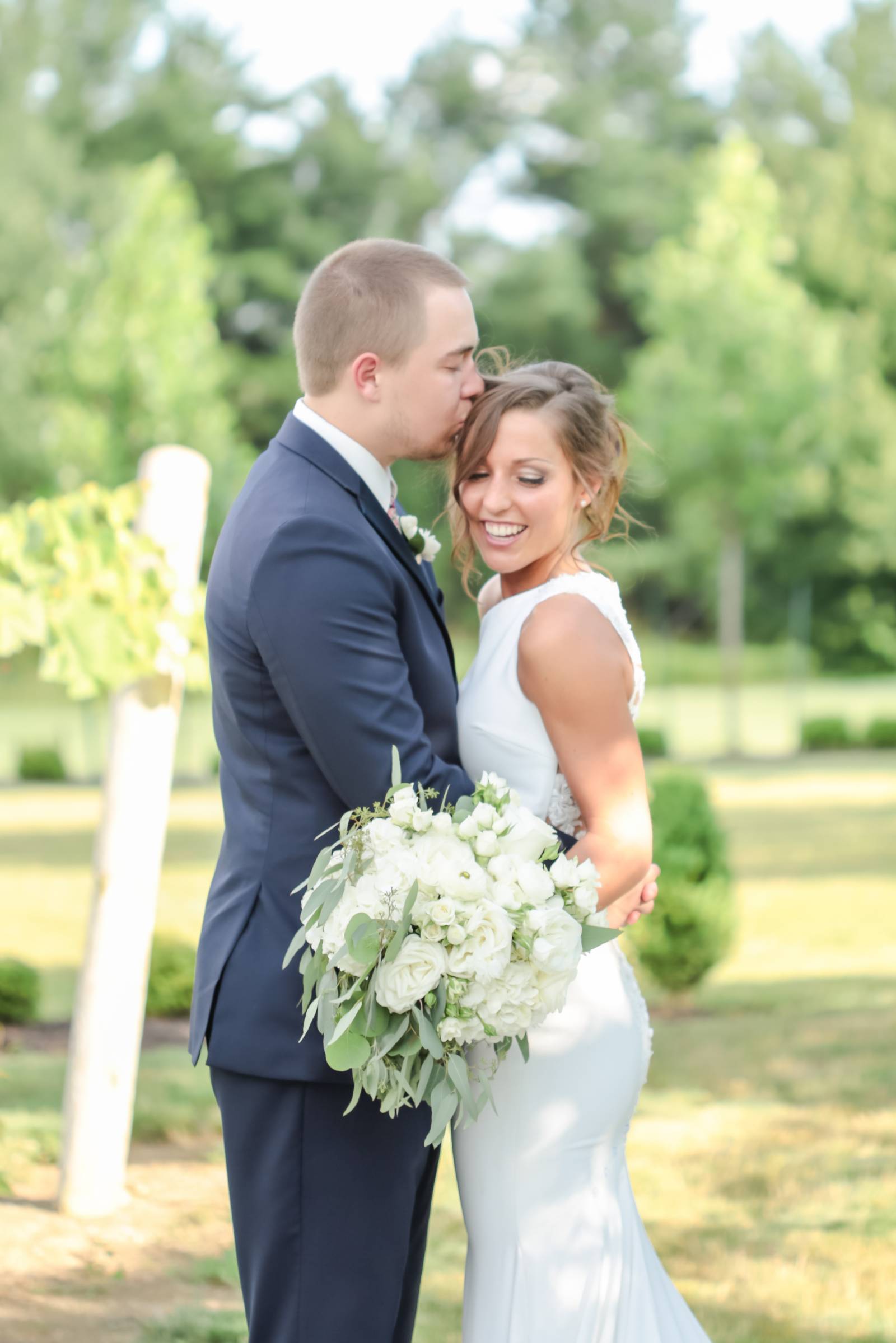 groom kissing brides head